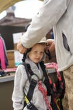 L'istruttore adulto mette l'attrezzatura su un ragazzo di 5 anni per gli sport estremi fotografia stock L'istruttore adulto mette l'attrezzatura su un ragazzo di 5 anni per gli sport estremi fotografia stock