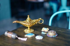 L?mpara m?gica Una lámpara mágica en la tabla con las galletas de azúcar y otros accesorios árabes como las botellas de la arena foto de archivo L?mpara m?gica Una lámpara mágica en la tabla con las galletas de azúcar y otros accesorios árabes como las botellas de la arena foto de archivo