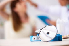 L'otorinolaringoiatra maschio di visita di medico della giovane donna fotografie stock libere da diritti L'otorinolaringoiatra maschio di visita di medico della giovane donna fotografie stock libere da diritti