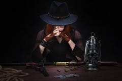 l?s v?stra flicka med revolvervapnet som sitter p? tabellen med ammunition- och silvermynt royaltyfri foto l?s v?stra flicka med revolvervapnet som sitter p? tabellen med ammunition- och silvermynt royaltyfri foto