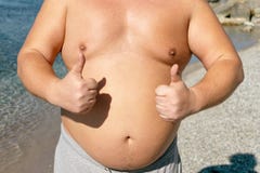 L'uomo grasso è riposante e godente del sole sulla spiaggia soleggiata immagini stock L'uomo grasso è riposante e godente del sole sulla spiaggia soleggiata immagini stock
