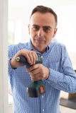 L'utilisation d'homme électrique forent dedans le projet de rénovation de Chambre Images libres de droits L'utilisation d'homme électrique forent dedans le projet de rénovation de Chambre Images libres de droits