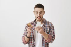 L'épouse a dépensé tout son salaire Tir d'intérieur du type caucasien stunned et stupéfait tenant le smartphone et de la carte de image stock L'épouse a dépensé tout son salaire Tir d'intérieur du type caucasien stunned et stupéfait tenant le smartphone et de la carte de image stock