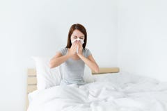 L'éternuement de jeune dame sur le lit et a besoin de plus de repos photo libre de droits L'éternuement de jeune dame sur le lit et a besoin de plus de repos photo libre de droits