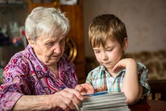 La abuela muestra el álbum de foto del nieto Familia Imágenes de archivo libres de regalías La abuela muestra el álbum de foto del nieto Familia Imágenes de archivo libres de regalías