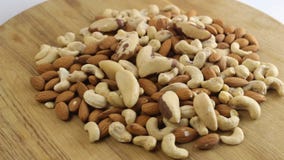 La almendra, el anacardo y las nueces brasileñas están haciendo girar a bordo almacen de metraje de vídeo La almendra, el anacardo y las nueces brasileñas están haciendo girar a bordo almacen de metraje de vídeo