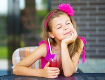 La bambina sta bevendo il succo della ciliegia Fotografie Stock La bambina sta bevendo il succo della ciliegia Fotografie Stock