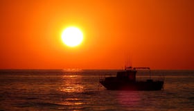 La barca vicino al tramonto su Mar Nero fotografia stock libera da diritti La barca vicino al tramonto su Mar Nero fotografia stock libera da diritti