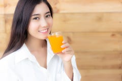 La bella donna asiatica attraente sta bevendo il succo d'arancia fascino immagine stock La bella donna asiatica attraente sta bevendo il succo d'arancia fascino immagine stock