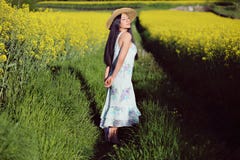 La bella donna asiatica di estate ha fiorito il campo immagine stock libera da diritti La bella donna asiatica di estate ha fiorito il campo immagine stock libera da diritti
