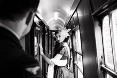 La bella donna si è vestita in vestito d'annata dal tè del tè rosso sul treno locomotivo fotografie stock libere da diritti La bella donna si è vestita in vestito d'annata dal tè del tè rosso sul treno locomotivo fotografie stock libere da diritti
