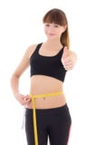 La bella donna sportiva esile con nastro adesivo della misura sfoglia sull'isolato su immagini stock libere da diritti La bella donna sportiva esile con nastro adesivo della misura sfoglia sull'isolato su immagini stock libere da diritti
