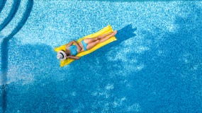 La bella ragazza che si rilassa nella piscina, nuotate sul materasso gonfiabile e si diverte in acqua sulla vacanza di famiglia, fotografie stock La bella ragazza che si rilassa nella piscina, nuotate sul materasso gonfiabile e si diverte in acqua sulla vacanza di famiglia, fotografie stock