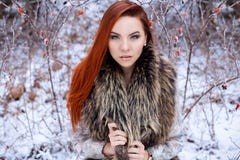 La bella ragazza sexy sveglia con capelli rossi che cammina in una foresta nevosa fra gli alberi ha mancato i primi cespugli di t Immagini Stock Libere da Diritti La bella ragazza sexy sveglia con capelli rossi che cammina in una foresta nevosa fra gli alberi ha mancato i primi cespugli di t Immagini Stock Libere da Diritti