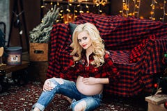 La belle et élégante femme caucasienne enceinte dans le T-shirt et des blues-jean avec les cheveux blonds tient son ventre, éléga image libre de droits La belle et élégante femme caucasienne enceinte dans le T-shirt et des blues-jean avec les cheveux blonds tient son ventre, éléga image libre de droits