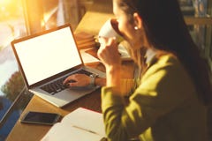 La belle femme d'affaires avec les cheveux foncés et le chandail jaune travaille dans coworking en café à l'intérieur utilisant l photographie stock La belle femme d'affaires avec les cheveux foncés et le chandail jaune travaille dans coworking en café à l'intérieur utilisant l photographie stock
