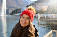 La belle femme de sourire avec les dents blanches et l'hiver vêtx dehors avec le lac suisse sur le fond et le soleil léger de fus photo stock La belle femme de sourire avec les dents blanches et l'hiver vêtx dehors avec le lac suisse sur le fond et le soleil léger de fus photo stock