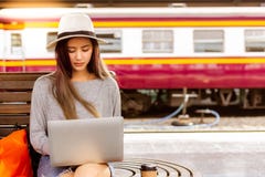 La belle femme utilise l'ordinateur portable à la station de train avant beau voyage asiatique de charme de femme à la destinatio photos stock La belle femme utilise l'ordinateur portable à la station de train avant beau voyage asiatique de charme de femme à la destinatio photos stock