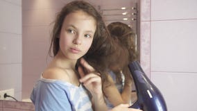 La belle fille de l'adolescence sèche des cheveux un hairdryer dans la vidéo de longueur d'actions de salle de bains banque de vidéos La belle fille de l'adolescence sèche des cheveux un hairdryer dans la vidéo de longueur d'actions de salle de bains banque de vidéos