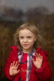 La belle fille heureuse dans une veste rouge regarde par le vitrail pleuvant photographie stock La belle fille heureuse dans une veste rouge regarde par le vitrail pleuvant photographie stock