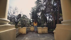 La belle fille va au balcon antique avec la vue sur le jardin vert un jour ensoleillé chaud banque de vidéos La belle fille va au balcon antique avec la vue sur le jardin vert un jour ensoleillé chaud banque de vidéos