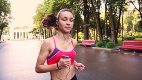 La belle jeune formation modèle de fille fonctionne en parc, mouvement lent clips vidéos La belle jeune formation modèle de fille fonctionne en parc, mouvement lent clips vidéos
