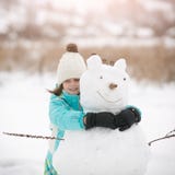 La belle petite fille sculpte le bonhomme de neige Photo libre de droits La belle petite fille sculpte le bonhomme de neige Photo libre de droits
