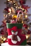 La bota de Santa Claus con las chucherías de la Navidad se cierra por completo encima del árbol de navidad en fondo fotos de archivo libres de regalías La bota de Santa Claus con las chucherías de la Navidad se cierra por completo encima del árbol de navidad en fondo fotos de archivo libres de regalías