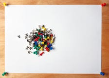 La carta e molte colorano le puntine da disegno rosse, blu, verde, giallo, bianco Uno strato dell'allegato di al bordo di legno immagine stock La carta e molte colorano le puntine da disegno rosse, blu, verde, giallo, bianco Uno strato dell'allegato di al bordo di legno immagine stock