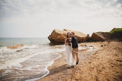 La cerimonia di nozze all'aperto della spiaggia vicino al mare, lo sposo sorridente felice alla moda e la sposa stanno baciando e Fotografia Stock La cerimonia di nozze all'aperto della spiaggia vicino al mare, lo sposo sorridente felice alla moda e la sposa stanno baciando e Fotografia Stock