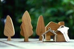 La chiave con il keychain della casa e di legno domestici treen ed a casa deridono su su fondo di legno d'annata, concetto della fotografie stock La chiave con il keychain della casa e di legno domestici treen ed a casa deridono su su fondo di legno d'annata, concetto della fotografie stock