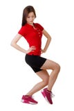 La chica joven en pantalones cortos cortos y una camisa de deportes realiza posiciones en cuclillas Aislado Imagenes de archivo La chica joven en pantalones cortos cortos y una camisa de deportes realiza posiciones en cuclillas Aislado Imagenes de archivo