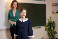 La colegiala sonriente realiza la tarea en la pizarra Educación imagen de archivo libre de regalías La colegiala sonriente realiza la tarea en la pizarra Educación imagen de archivo libre de regalías