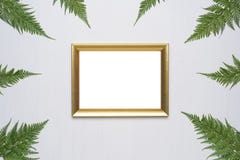 La composition minimale élégante avec le cadre et le vert de photo part sur un fond en bois blanc photographie stock La composition minimale élégante avec le cadre et le vert de photo part sur un fond en bois blanc photographie stock