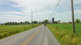 La conducción a lo largo del campo de Amish pareció el caballo 2 y el cochecillo abierto almacen de metraje de vídeo La conducción a lo largo del campo de Amish pareció el caballo 2 y el cochecillo abierto almacen de metraje de vídeo