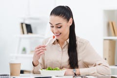 la consommation de sourire de femme d'affaires emportent la salade pour le déjeuner image stock la consommation de sourire de femme d'affaires emportent la salade pour le déjeuner image stock