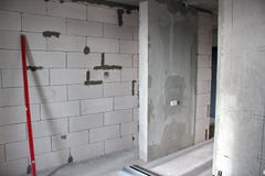 La construction des murs dans l'appartement avec une disposition libre la construction des murs des blocs de silicate avec le lev photo libre de droits La construction des murs dans l'appartement avec une disposition libre la construction des murs des blocs de silicate avec le lev photo libre de droits