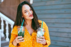 La consumición de la mujer del tamaño extra grande se lleva el cóctel sobre la pared del café de la ciudad fotografía de archivo libre de regalías La consumición de la mujer del tamaño extra grande se lleva el cóctel sobre la pared del café de la ciudad fotografía de archivo libre de regalías
