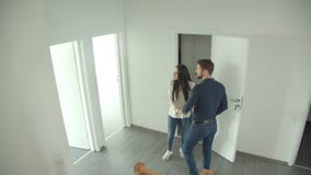 La coppia caucasica scala le scale ed esamina intorno un nuovo appartamento La coppia caucasica scala le scale ed esamina intorno un nuovo appartamento