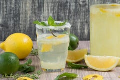 La cruche et le verre de whith de limonade monnayent sur la table en bois image libre de droits La cruche et le verre de whith de limonade monnayent sur la table en bois image libre de droits