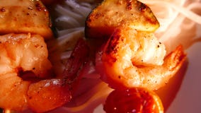 La cuisine de fusion chinoise thaïlandaise, nouilles avec des crevettes roses a fait frire sur des brochettes closeup La cuisine de fusion chinoise thaïlandaise, nouilles avec des crevettes roses a fait frire sur des brochettes closeup