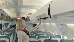 La dame assez jeune met son bagage au support à l'avion clips vidéos La dame assez jeune met son bagage au support à l'avion clips vidéos