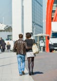 La defense, France- April 10, 2014: Stylish couple walking in a street. The man is wearing blue jean's and the woman short grey sk royalty free stock photo La defense, France- April 10, 2014: Stylish couple walking in a street. The man is wearing blue jean's and the woman short grey sk royalty free stock photo