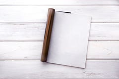 La derisione vuota aperta di bianco sulla pagina della rivista sulla linguetta di legno bianca fotografia stock libera da diritti La derisione vuota aperta di bianco sulla pagina della rivista sulla linguetta di legno bianca fotografia stock libera da diritti