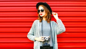 La donna alla moda del ritratto di autunno del ritratto tiene la retro macchina fotografica immagine stock libera da diritti La donna alla moda del ritratto di autunno del ritratto tiene la retro macchina fotografica immagine stock libera da diritti