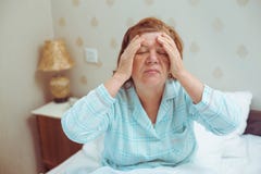 La donna anziana preoccupata ha emicrania a casa fotografie stock La donna anziana preoccupata ha emicrania a casa fotografie stock