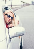 La donna bionda abbastanza giovane guarda fuori dalla finestra di automobile Immagine Stock La donna bionda abbastanza giovane guarda fuori dalla finestra di automobile Immagine Stock