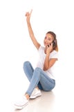La donna casuale sorridente indica su e parla sul suo telefono Fotografie Stock La donna casuale sorridente indica su e parla sul suo telefono Fotografie Stock