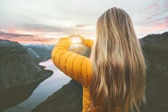 La donna che viaggia in montagne del tramonto passa il simbolo del cuore a forma di fotografie stock La donna che viaggia in montagne del tramonto passa il simbolo del cuore a forma di fotografie stock