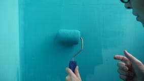La donna dipinge il blu del rullo della parete, pittore dell'artista del lavoro per arte della riparazione archivi video La donna dipinge il blu del rullo della parete, pittore dell'artista del lavoro per arte della riparazione archivi video